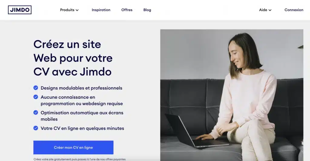 Femme utilisant un ordinateur portable sur canapé gris.