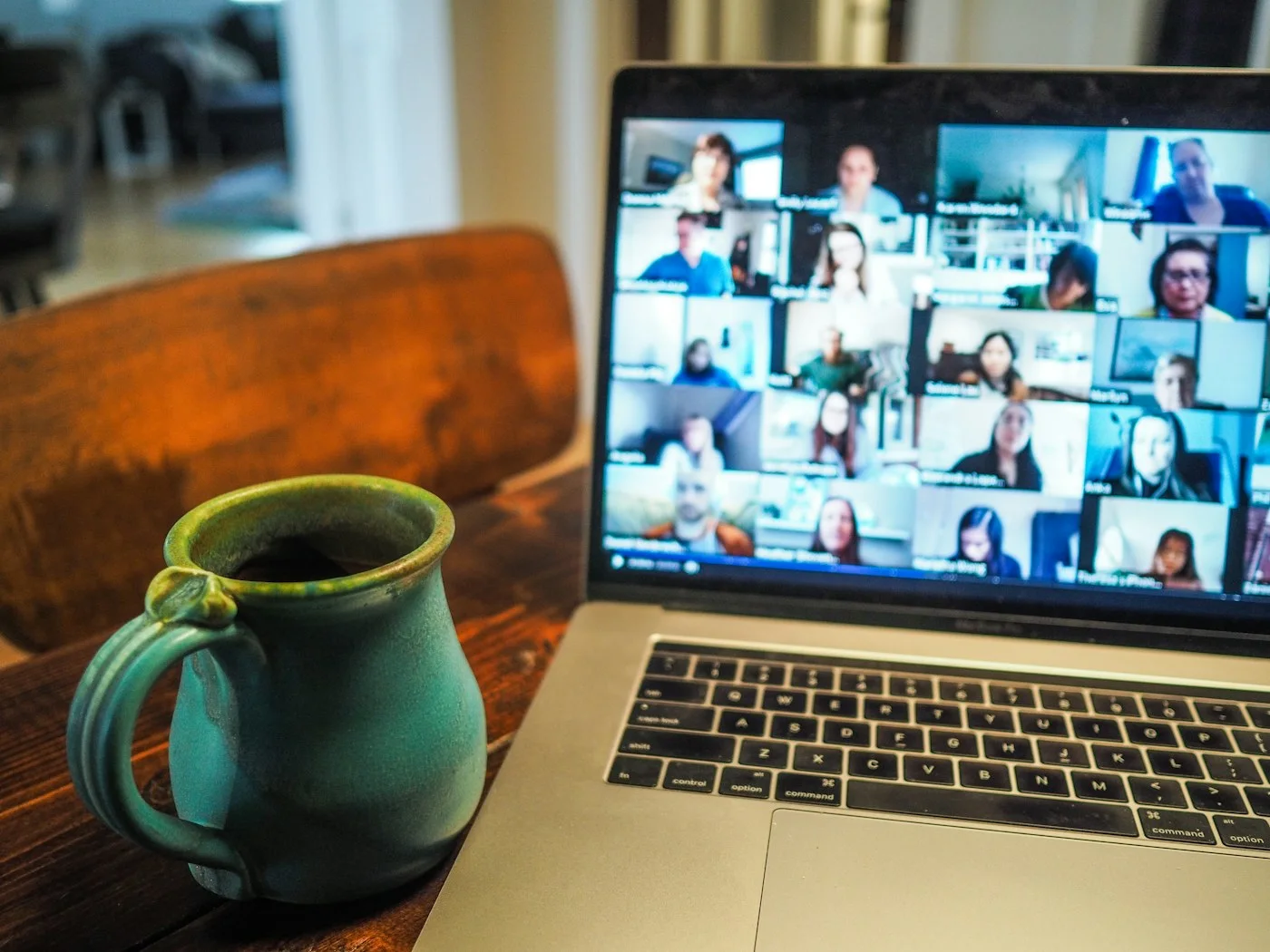 Visioconférence d'équipe affichée sur un ordinateur portable à côté d'une tasse